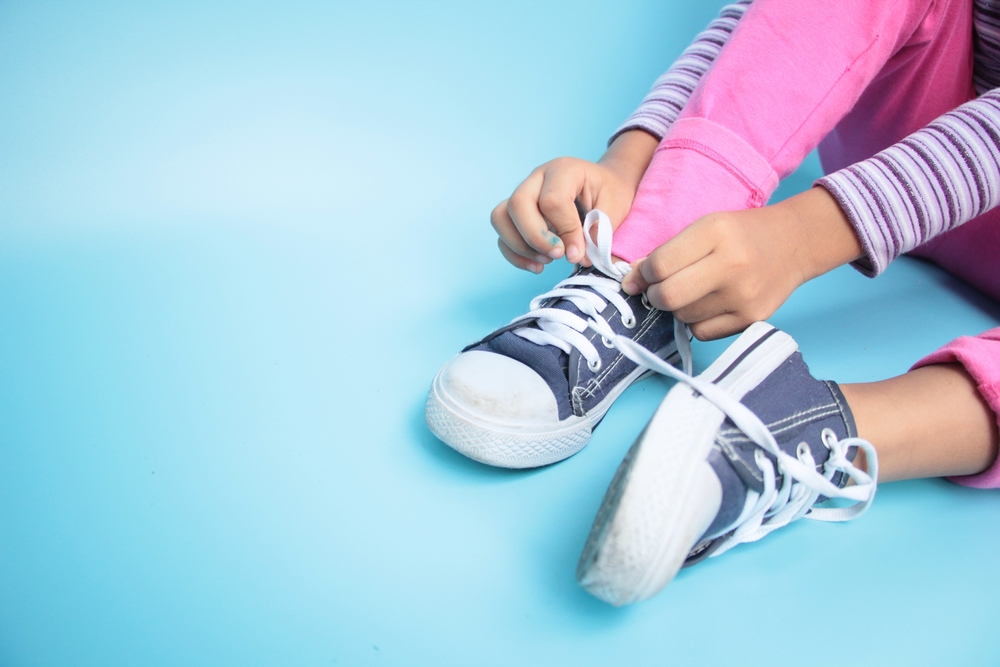 child tying shoes