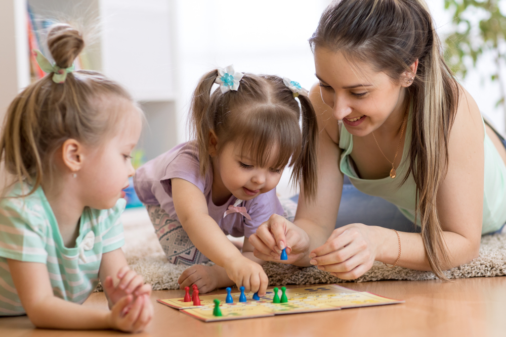 mom and two girls playing a board game