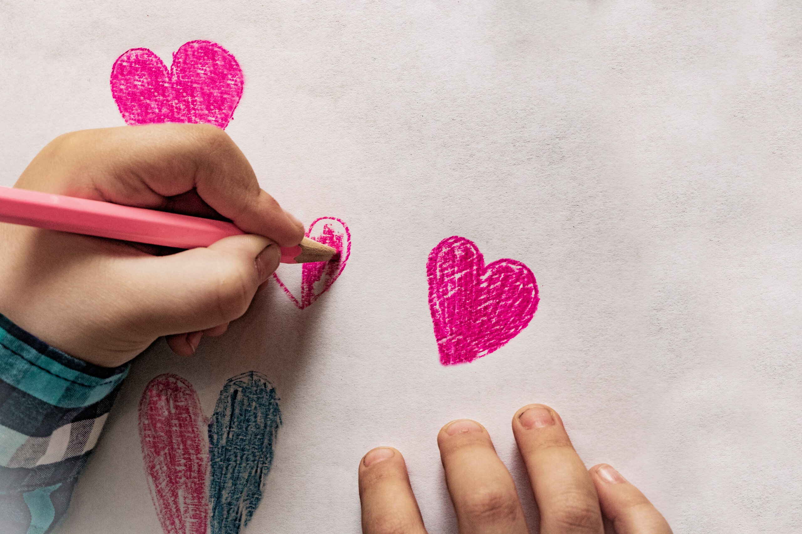 a child drawing hearts on paper