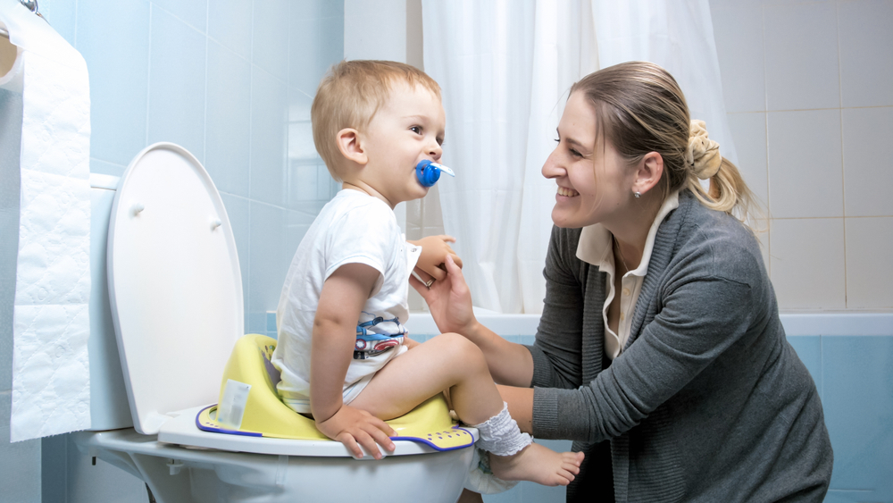 mom helping toddler potty train