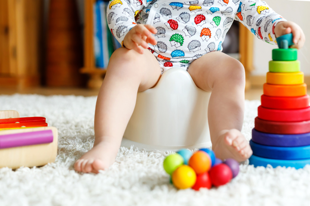 toddler on a potty chair playing