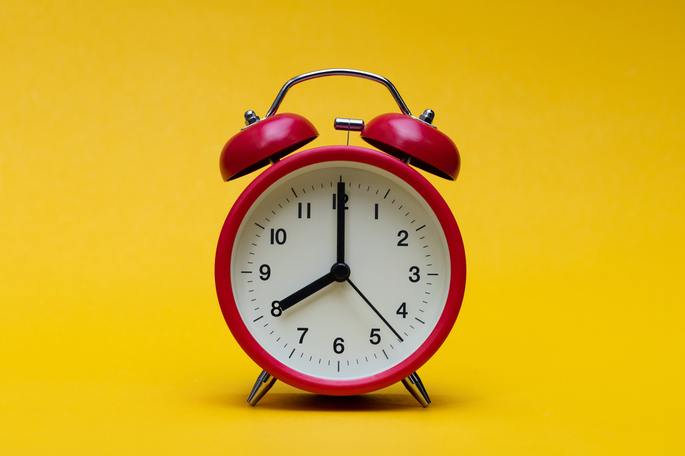 red alarm clock in a yellow background