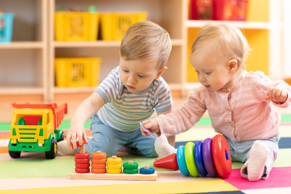 infant boy and girl playing in a preschool setting