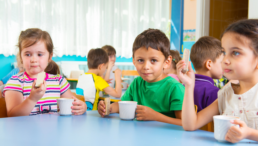 school-aged kids eating lunch at a table