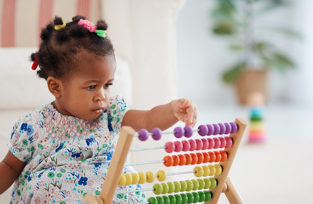 toddler girl playing with counting toy 