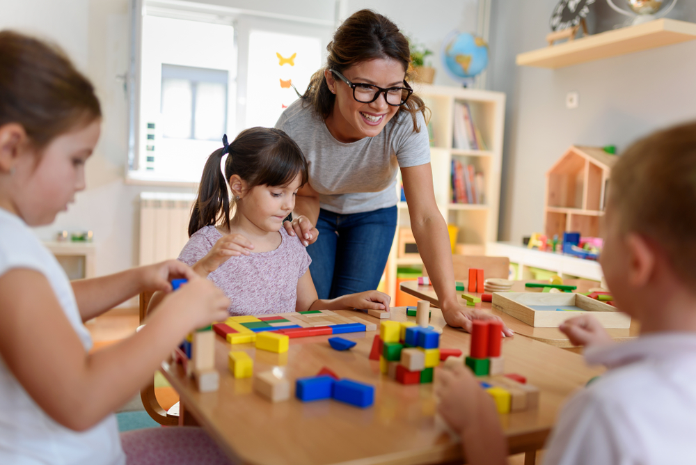 daycare teacher helping younger students